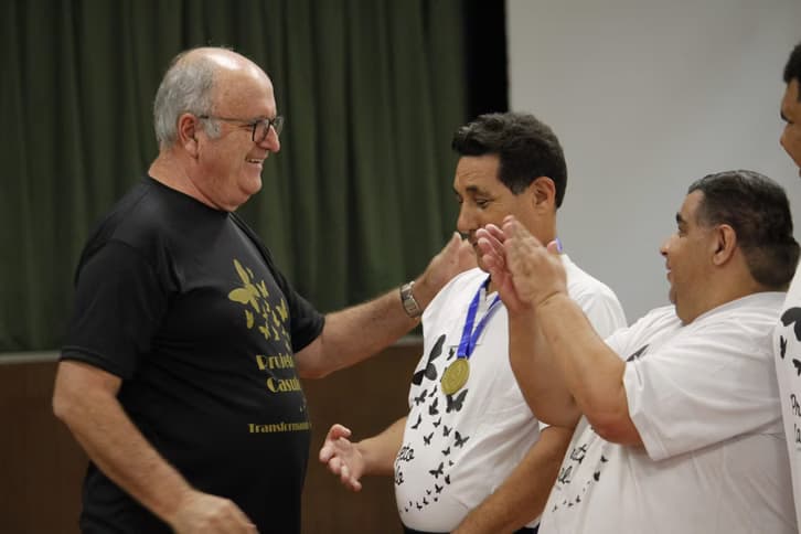 Participante recebendo camiseta do Projeto Casulo em atividade institucional