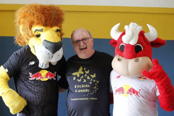 Representante da Acose Casulo com mascotes em evento comunitário